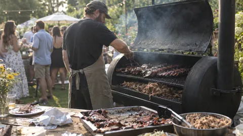 Grillmeister am Smoker beim Sommerfest-Catering