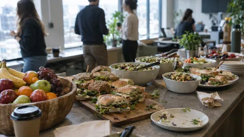 Team-Lunch mit Bowls, Sandwiches und Obstkorb in der Büroküche
